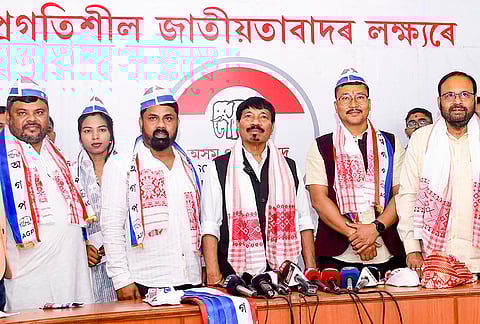 Assam Gana Parishad (AGP) president Atul Bora, center, and party working president Keshab Mahanta, right, with newly joined members during a joining programme at the party headquarters, in Guwahati. 