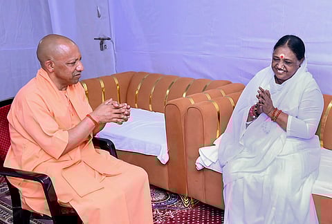 Uttar Pradesh Chief Minister Yogi Adityanath, left, meets spiritual leader Mata Amritanandamayi, in Ayodhya, Uttar Pradesh. 