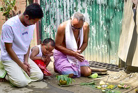 Meitei community members offer prayers with traditional food offerings outside a house during Cheiraoba, the Meitei New Year, in Imphal.