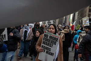 Source: IMAGO / ZUMA Press Wire : March 13, 2026, New York, New York, USA: A woman carries a sign that reads, "No More Forever Wars! Hands Off Iran!" at an Al Quds Day rally in Times Square marching to Herald Square to mark the last day of Ramadan and to protest the US-Israel war on Iran.