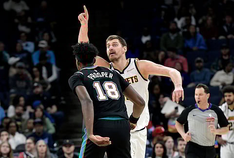 Denver Nuggets center Nikola Jokic, right, calls to teammates ahead of Memphis Grizzlies forward Olivier-Maxence Prosper (18) in the first half of an NBA basketball game in Memphis, Tennessee.