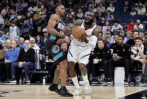 Denver Nuggets guard Tim Hardaway Jr., right, handles the ball against Memphis Grizzlies guard Javon Small in the first half of an NBA basketball game in Memphis, Tennessee.