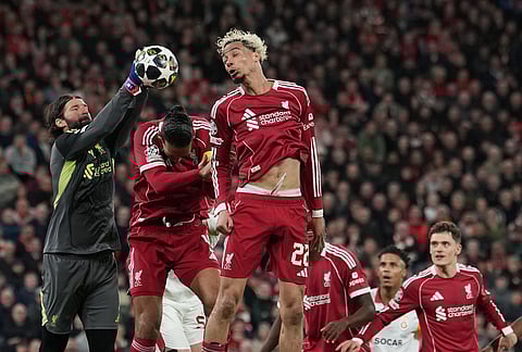 Liverpool's goalkeeper Alisson, left, makes a save during the second leg of the Champions League round of 16 soccer match between Liverpool and Galatasaray, in Liverpool, England.