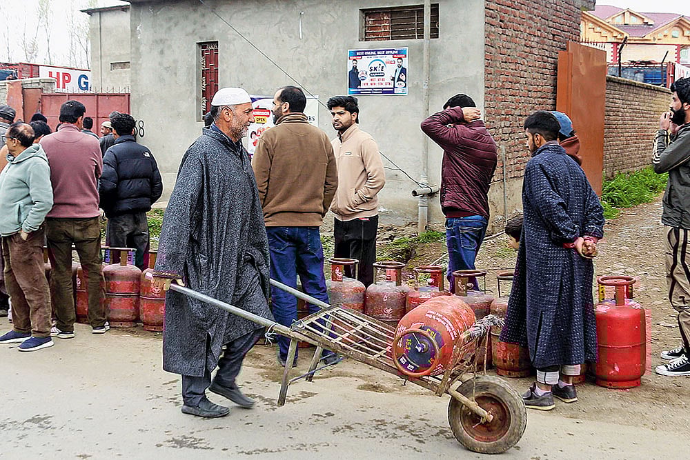Stocking Up: People line up to carry LPG cooking gas cylinders home in Pulwama, Kashmir - | Photo; PTI