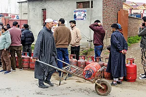 | Photo; PTI : Stocking Up: People line up to carry LPG cooking gas cylinders home in Pulwama, Kashmir
