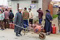 | Photo; PTI : Stocking Up: People line up to carry LPG cooking gas cylinders home in Pulwama, Kashmir