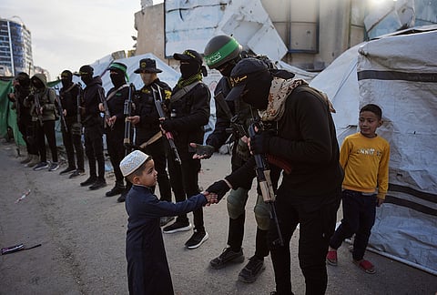 Palestinian militants from Hamas and Islamic Jihad greet people who gather for to Eid al-Fitr prayers in Gaza City, Friday, March 20, 2026.