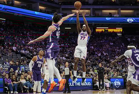Philadelphia 76ers guard Vj Edgecombe (77) shoots a three-point basket over Sacramento Kings center Maxime Raynaud (42) during the first half of an NBA basketball game in Sacramento, California.