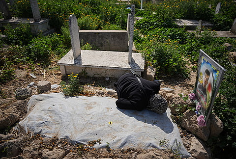 Riham Yassin visits the grave of her son, Abdullah Yassin, who was killed killed in the Israel-Hamas war, on the first day of the Muslim holiday of Eid al-Fitr in Gaza City, Friday, March 20, 2026. 