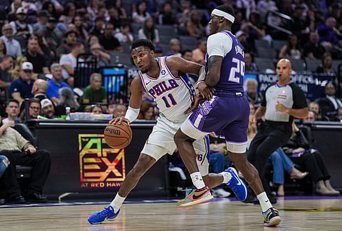 Philadelphia 76ers forward Justin Edwards (11) dribbles against Sacramento Kings guard Daeqwon Plowden during the first half of an NBA basketball game, in Sacramento, California.
