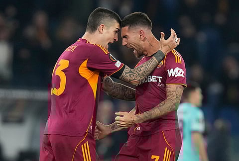 Roma's Gianluca Mancini, left, and Lorenzo Pellegrini celebrate after scoring during the Europa League round of 16 second leg soccer match between Roma and Bologna in Rome, Italy.