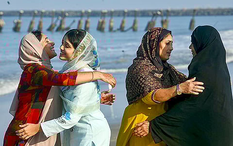 Women greet each other at an Eidgah as part of Eid al-Fitr celebrations, at Kozhikode beach, in Kerala.