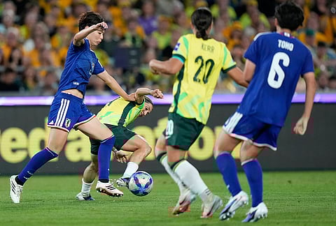 Japan's Saki Kumagai, left, tackles Australia's Katrina Gorry during the Women's Asian Cup soccer final between Japan and Australia in Sydney.