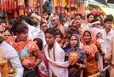 Devotees wait in a queue before offering prayers during the ‘Navaratri’ festival, at Vindhyavasini Temple in Mirzapur.