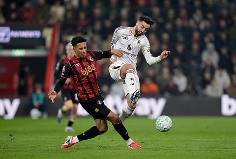 Bournemouth's James Hill, left, and Manchester United's Bruno Fernandes battle for the ball during an Premier League soccer match, in Bournemouth, England. 