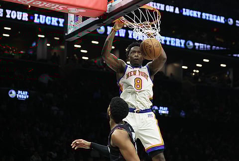 New York Knicks forward Og Anunoby (8) dunks over Brooklyn Nets forward Chaney Johnson, bottom, during the second half of an NBA basketball game, in New York.