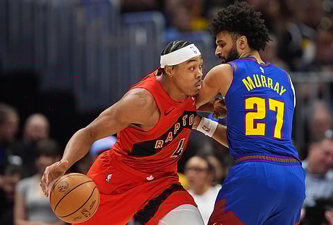 Toronto Raptors forward Scottie Barnes, left, drives past Denver Nuggets guard Jamal Murray (27) in the first half of an NBA basketball game in Denver.