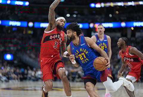 Denver Nuggets guard Jamal Murray, right, drives past Toronto Raptors forward Brandon Ingram in the first half of an NBA basketball game in Denver. 