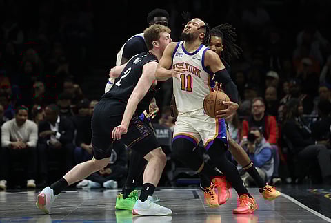 New York Knicks guard Jalen Brunson (11) is fouled during the first half of an NBA basketball game against the Brooklyn Nets, in New York.