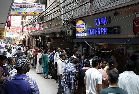 People queue up for LPG cylinder at an Indian Oil gas supply agency in New Delhi's Kalkaji area