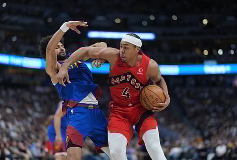 Toronto Raptors forward Scottie Barnes, right, pushes away Denver Nuggets guard Jamal Murray on the way to the rim in the second half of an NBA basketball game in Denver. 