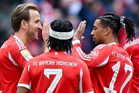 From left, Munich's scorer Harry Kane, Serge Gnabry and Michael Olise celebrate their side's third goal during the German Bundesliga soccer match between FC Bayern Munich and 1. FC Union Berlin in Munich, Germany.