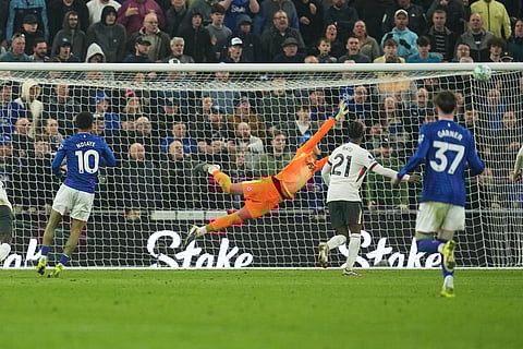 Everton's Iliman Ndiaye, left, scores his side's third goal past Chelsea's goalkeeper Robert Sanchez during the English Premier League soccer match between Everton and Chelsea in Liverpool, England.