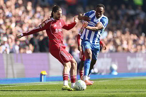 Liverpool's Dominik Szoboszlai, left, and Brighton's Danny Welbeck fight for the ball during the English Premier League soccer match between Brighton and Liverpool in Brighton.