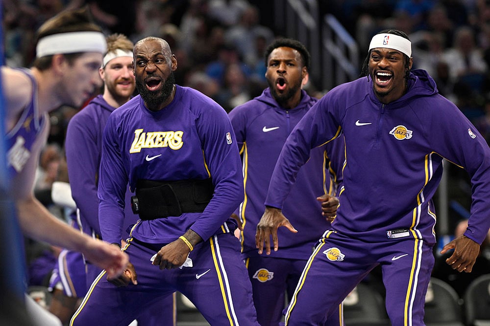 Los Angeles Lakers forward LeBron James, second from front right, and forward Jarred Vanderbilt, right, react after a dunk by guard Austin Reaves, left, during the first half of an NBA basketball game against the Orlando Magic in Orlando, Fla. - | Photo: AP/Phelan M. Ebenhack