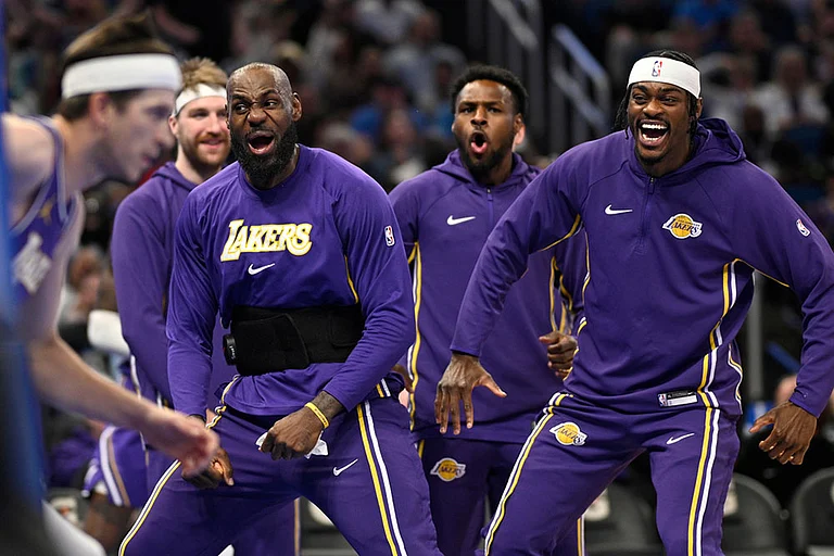 Los Angeles Lakers forward LeBron James, second from front right, and forward Jarred Vanderbilt, right, react after a dunk by guard Austin Reaves, left, during the first half of an NBA basketball game against the Orlando Magic in Orlando, Fla. - | Photo: AP/Phelan M. Ebenhack