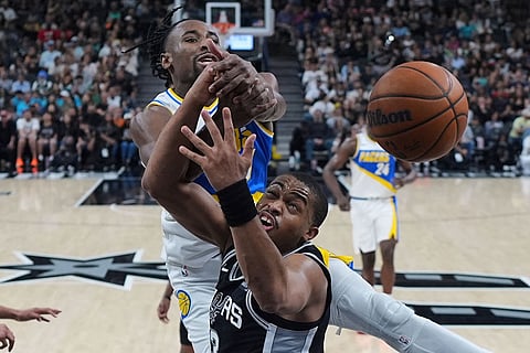 Indiana Pacers guard Aaron Nesmith, left, and San Antonio Spurs forward Keldon Johnson, right, battle for a rebound during the second half of an NBA basketball game in San Antonio.