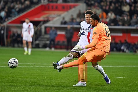 PSG's Desire Doue challenges Nice's goalkeeper Yehvann Diouf during the French League One soccer match between Nice and Paris Saint-Germain in Nice, France.