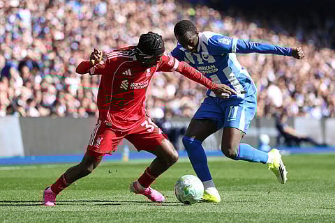 Liverpool's Jeremie Frimpong, left, and Brighton's Yankuba Minteh fight for the ball during the English Premier League soccer match between Brighton and Liverpool in Brighton.