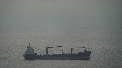 A cargo ship carrying vehicles sails through the Arabian Gulf toward the Strait of Hormuz in the United Arab Emirates.