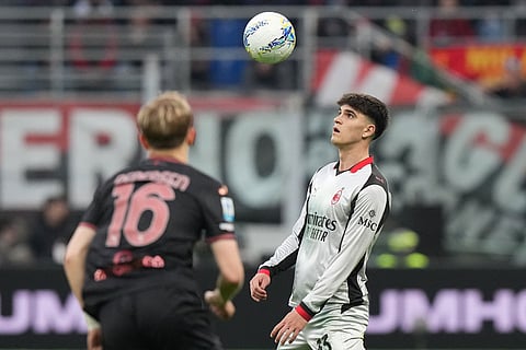 AC Milan's Davide Bartesaghi, right, eyes the ball past Torino's Marcus Pedersen during the Serie A soccer match between AC Milan and Torino, in Milan, Italy.