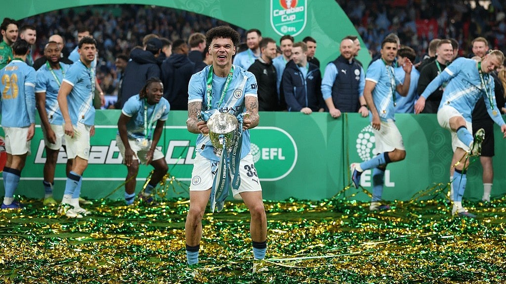 Manchester City's Nico O'Reilly celebrates with the trophy after winning the English League Cup final soccer match between Arsenal and Manchester City in London, Sunday, March 22, 2026. - AP Photo 