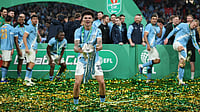 AP Photo  : Manchester City's Nico O'Reilly celebrates with the trophy after winning the English League Cup final soccer match between Arsenal and Manchester City in London, Sunday, March 22, 2026.