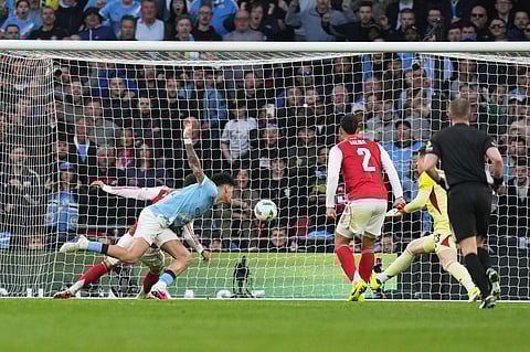 Manchester City's Nico O'Reilly, heads the ball and scores the opening goal during the English League Cup final soccer match between Arsenal and Manchester City in London, Sunday, March 22, 2026.