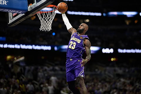 Los Angeles Lakers forward LeBron James (23) scores on a breakaway dunk during the first half of an NBA basketball game against the Orlando Magic in Orlando, Fla.