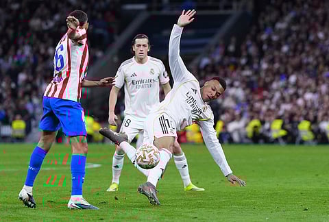Real Madrid's Kylian Mbappe, right, and Atletico Madrid's Koke challenge for the ball during the Spanish La Liga soccer match between Real Madrid and Atletico Madrid in Madrid, Spain.