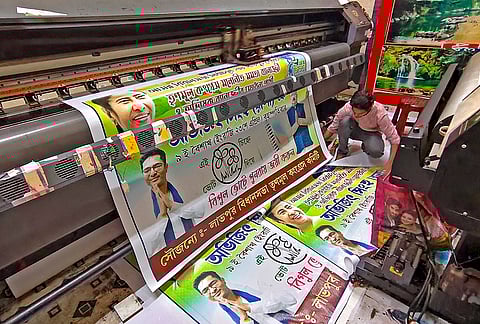 A worker sorts flex sheet prints of the TMC party during preparations for the upcoming West Bengal Assembly elections at Bolpur in Birbhum district.