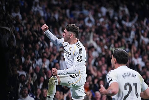 Real Madrid's Federico Valverde, left, celebrates after scoring his side's second goal the Spanish La Liga soccer match between Real Madrid and Atletico Madrid in Madrid, Spain.
