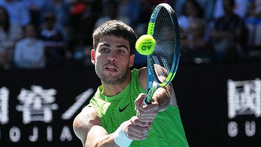 Carlos Alcaraz of Spain plays a backhand return to Yannick Hanfmann of Germany during their second round match at the Australian Open tennis championship in Melbourne, Australia. - | Photo: AP/Dita Alangkara