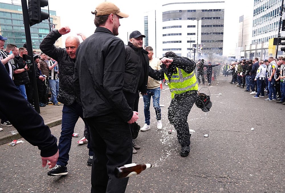 A police officer reacts as a bottle is thrown during clashes between Sunderland and Newcastle United fans before the Premier League match between Newcastle and Sunderland outside St James' Park, Newcastle upon Tyne, England. - | Photo: Owen Humphreys/PA via AP