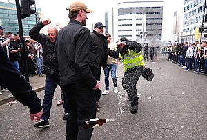 | Photo: Owen Humphreys/PA via AP : A police officer reacts as a bottle is thrown during clashes between Sunderland and Newcastle United fans before the Premier League match between Newcastle and Sunderland outside St James' Park, Newcastle upon Tyne, England.