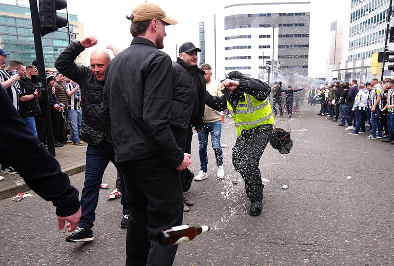 A police officer reacts as a bottle is thrown during clashes between Sunderland and Newcastle United fans before the Premier League match between Newcastle and Sunderland outside St James' Park, Newcastle upon Tyne, England. - | Photo: Owen Humphreys/PA via AP