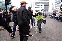 | Photo: Owen Humphreys/PA via AP : A police officer reacts as a bottle is thrown during clashes between Sunderland and Newcastle United fans before the Premier League match between Newcastle and Sunderland outside St James' Park, Newcastle upon Tyne, England.