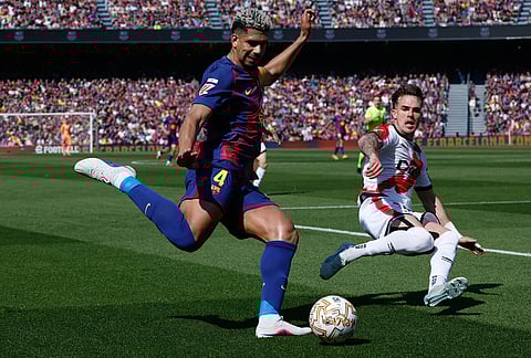 Barcelona's Ronald Araujo sends a cross by Rayo's Pep Chavarria during a La Liga soccer match between Barcelona and Rayo Vallecano in Barcelona, Spain.