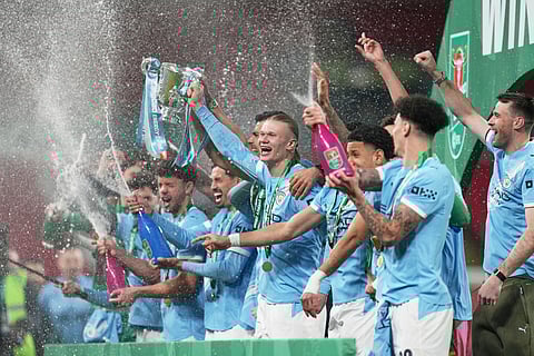 Manchester City's Erling Haaland. Hold up the cup as his teammates celebrate after winning the English League Cup final soccer match between Arsenal and Manchester City in London, Sunday, March 22, 2026. 