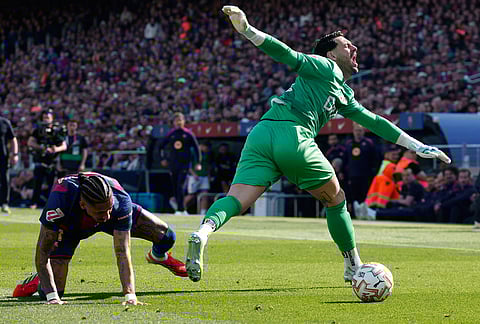 Barcelona's Raphinha fouls Rayo's goalkeeper Augusto during a La Liga soccer match between Barcelona and Rayo Vallecano in Barcelona, Spain.